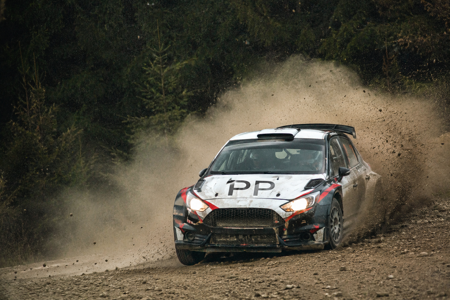 A high-speed rally car racing on a dirt track, showcasing Prusa Partners' logo and representing dynamic acceleration and growth